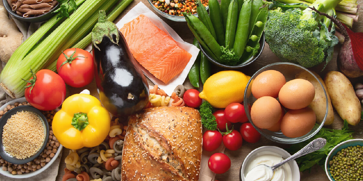 A table spread with vegetables and various food.